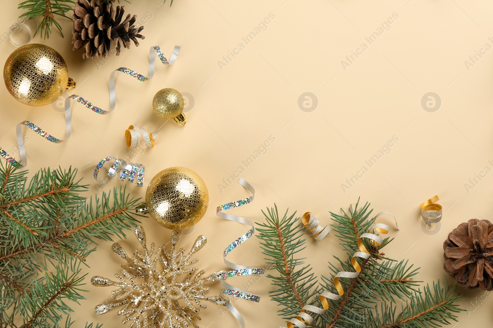 Photo of Flat lay composition with serpentine streamers and Christmas decor on beige background. Space for text