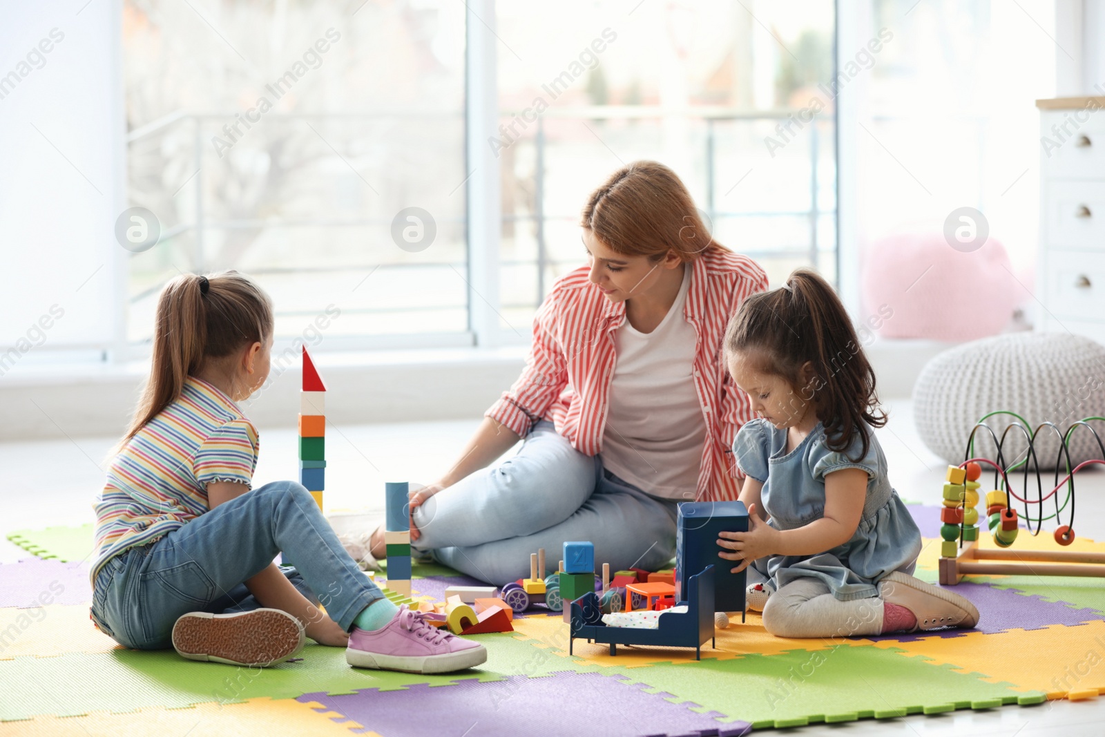 Photo of Mother playing with her children at home