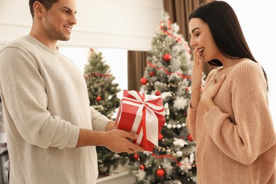 Happy couple with Christmas gift at home