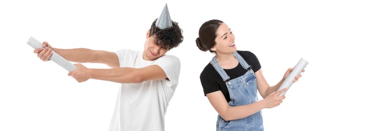 Image of Young man and woman blowing up party poppers on white background