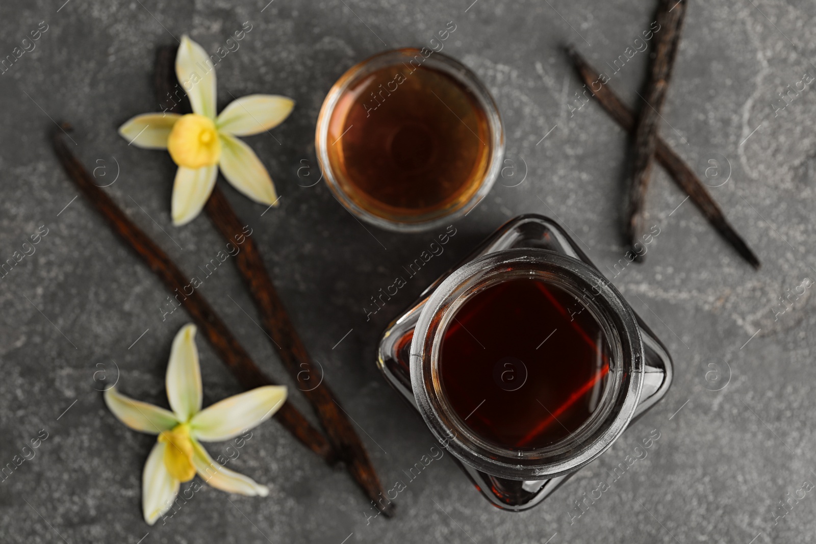 Photo of Flat lay composition with vanilla extract on grey table