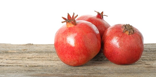 Fresh pomegranates on wooden table against white background, space for text