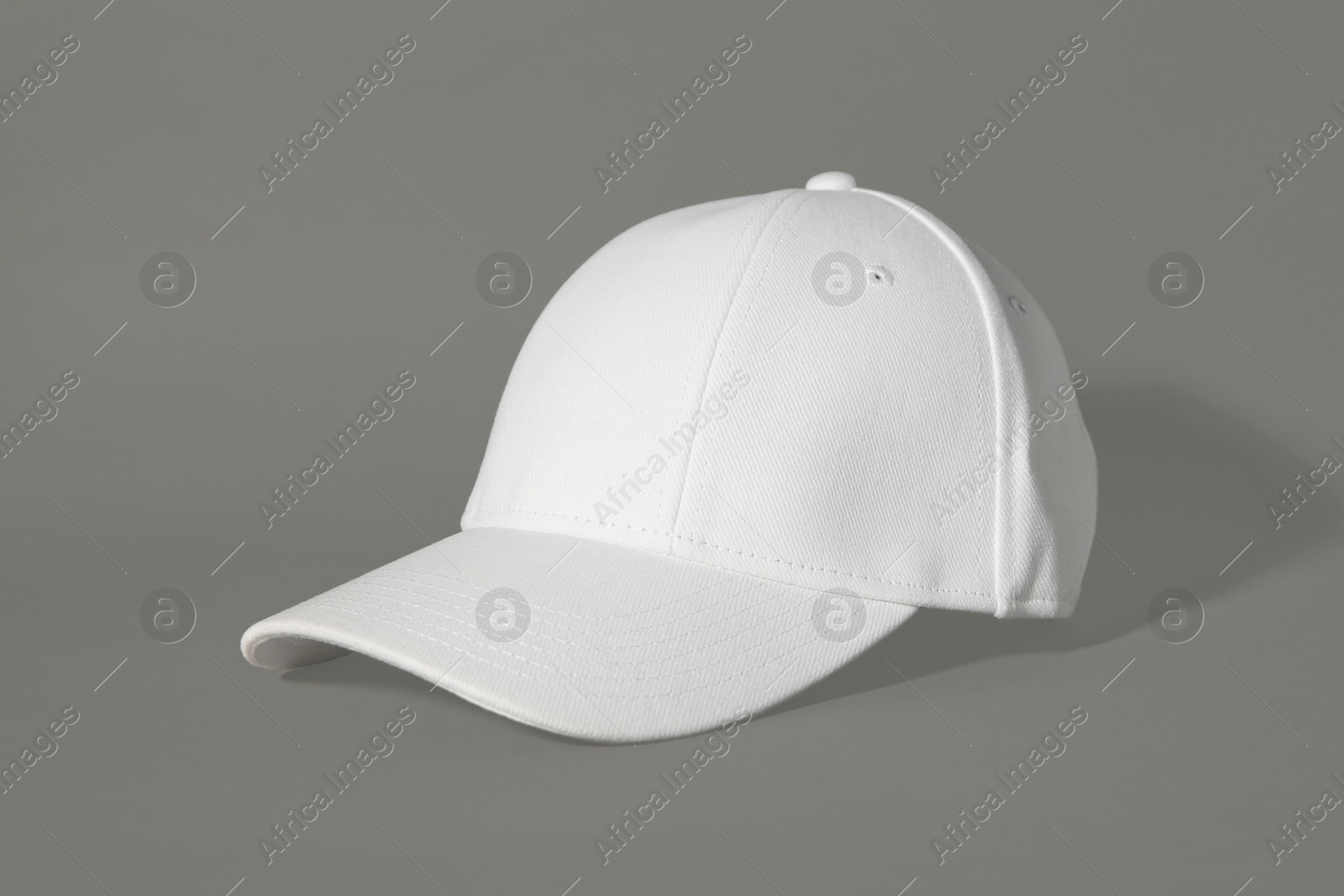 Photo of Stylish white baseball cap on grey background