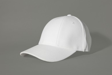 Photo of Stylish white baseball cap on grey background