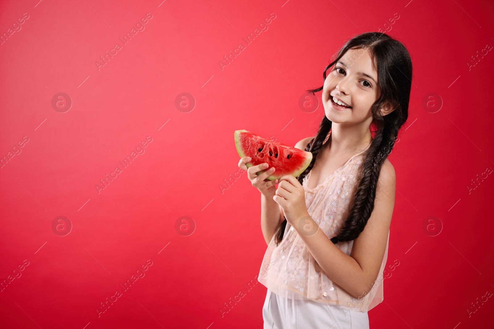 Photo of Cute little girl with watermelon on red background. Space for text