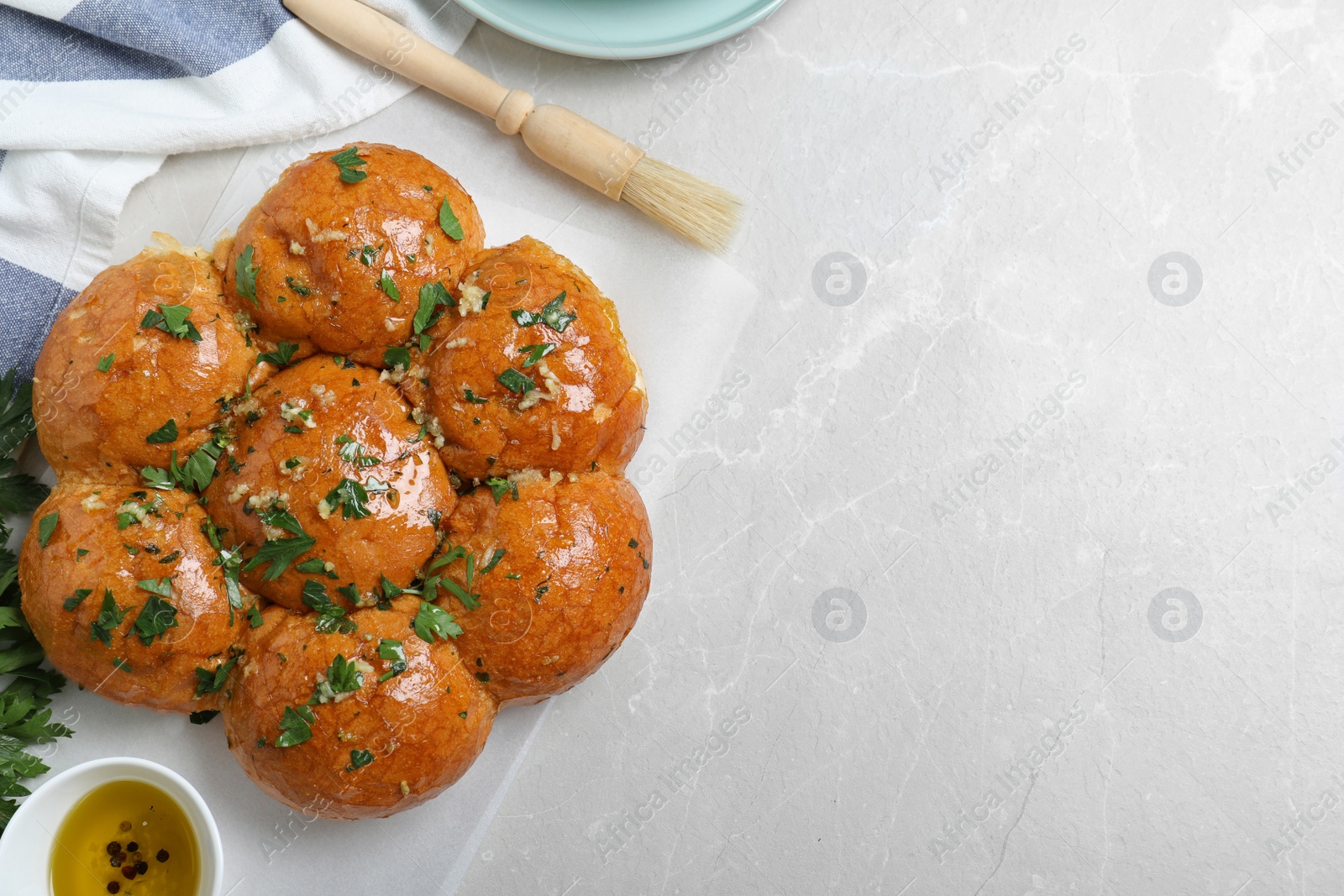 Photo of Traditional Ukrainian garlic bread (Pampushky) on light marble table, flat lay. Space for text