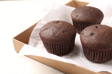 Photo of Delicious fresh chocolate cupcakes on white table, closeup