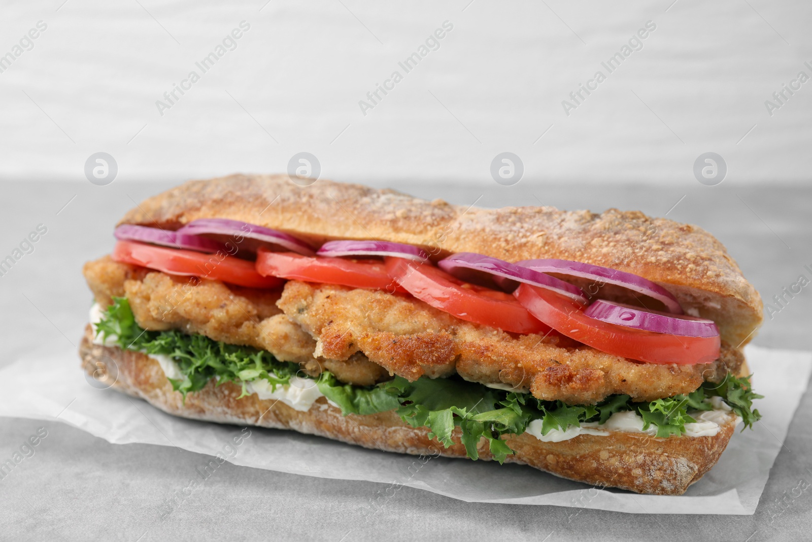Photo of Delicious sandwich with schnitzel on grey table, closeup