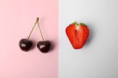 Sweet red cherries and strawberry on color background