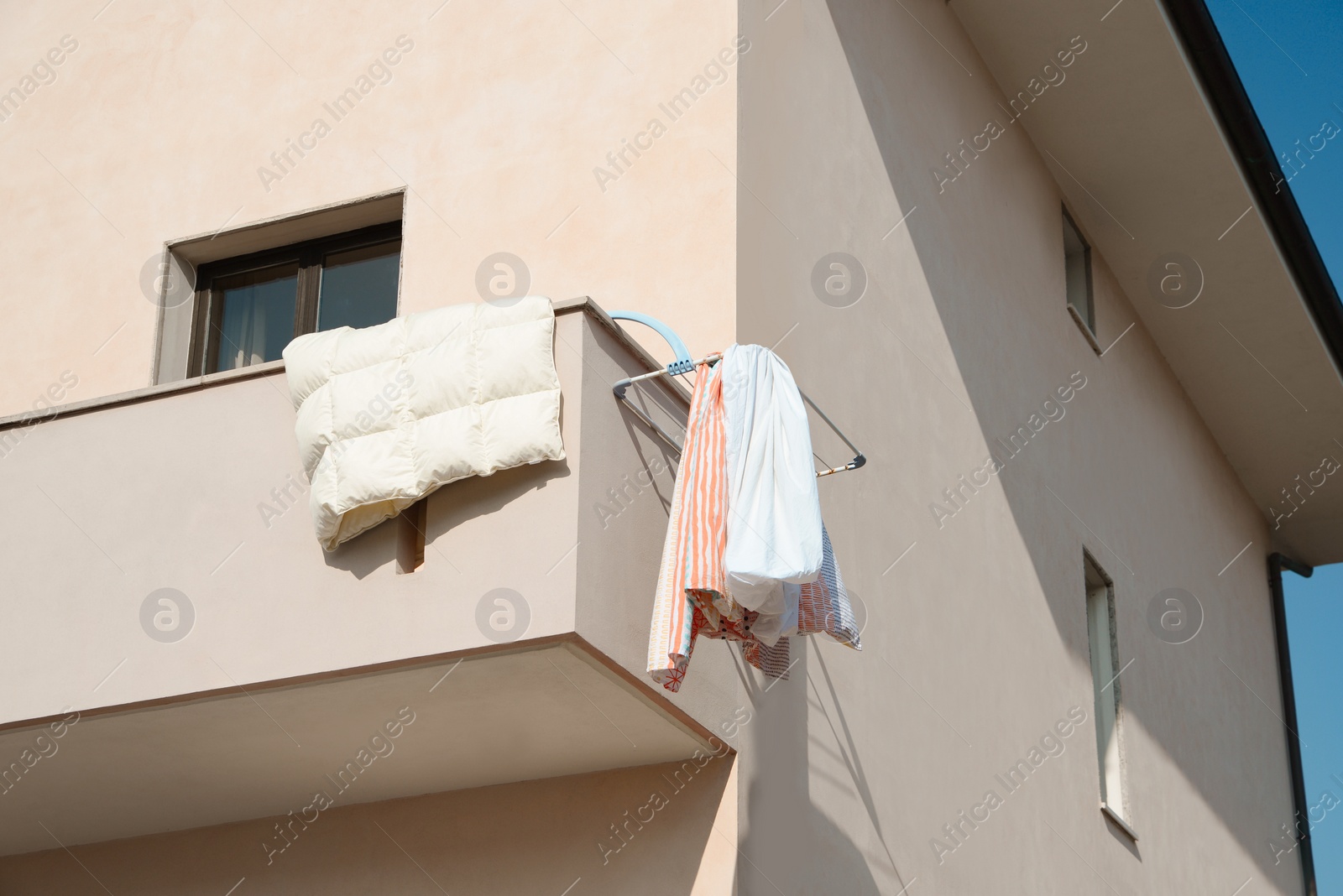 Photo of Balcony with drying laundry on sunny day, low angle view