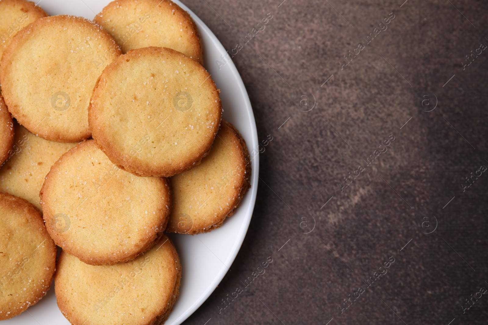 Photo of Tasty sweet sugar cookies on brown table, top view. Space for text