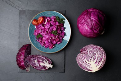 Photo of Tasty fresh red cabbages on black table, flat lay