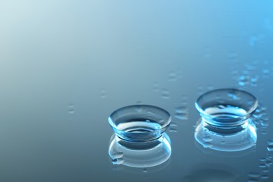 Pair of contact lenses on wet mirror surface. Space for text