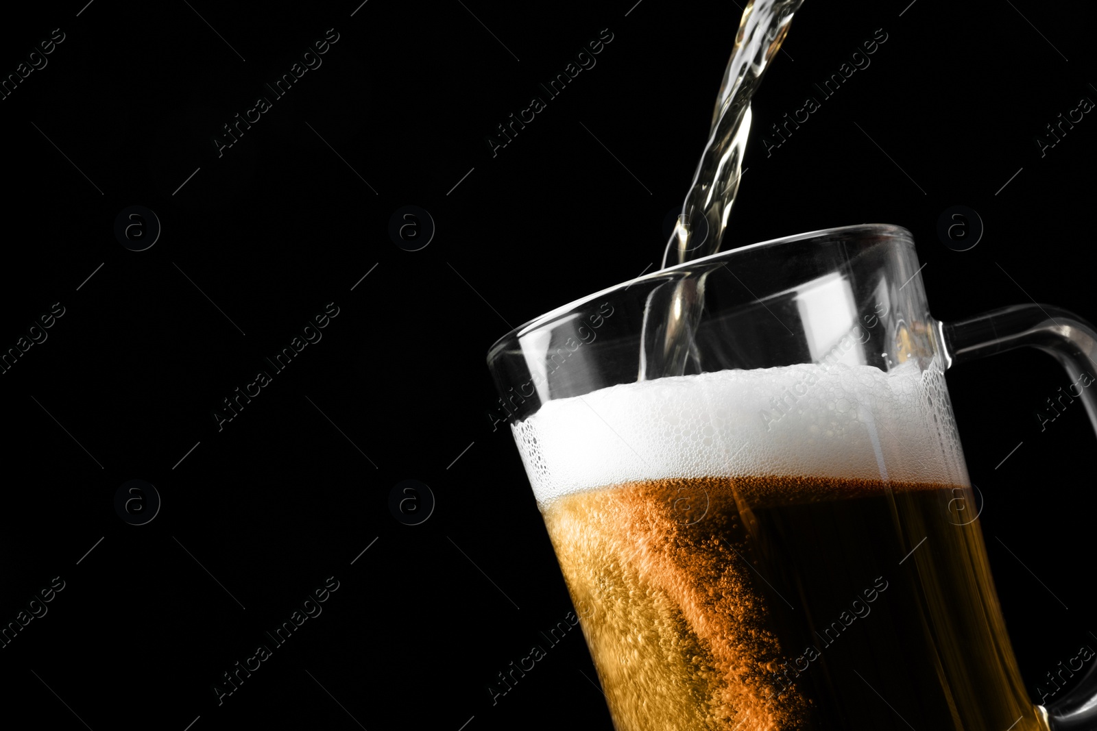 Photo of Pouring cold tasty beer into glass mug on black background, closeup. Space for text