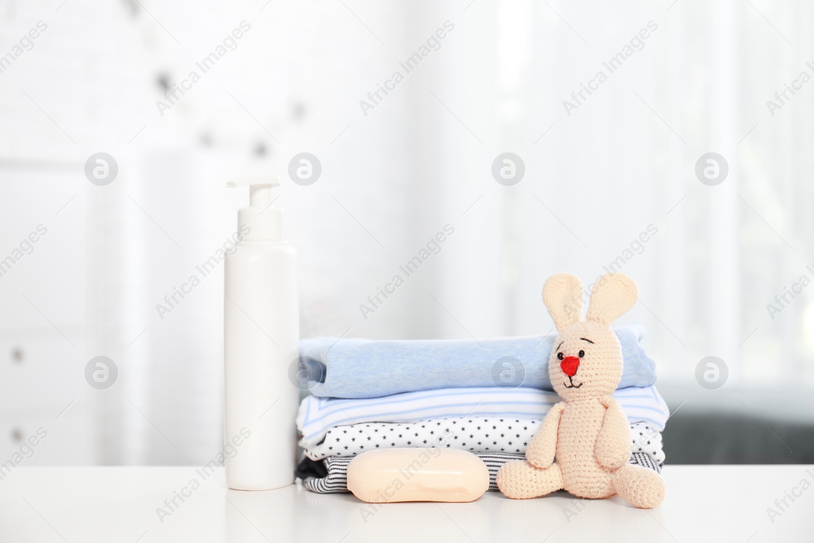 Photo of Baby accessories on table in nursery room. Space for text