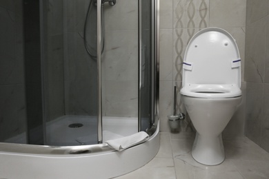 Photo of Modern bathroom interior with clean toilet bowl and shower cabin