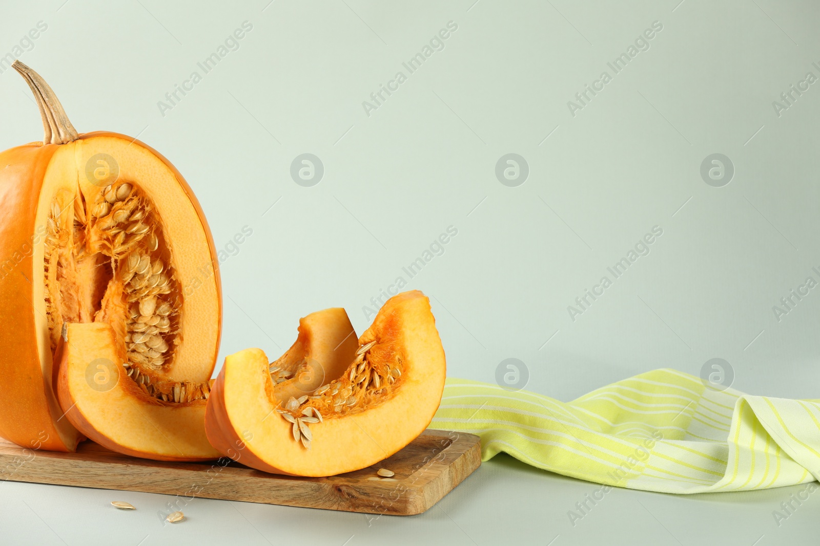 Photo of Cut fresh ripe pumpkin on white background, space for text