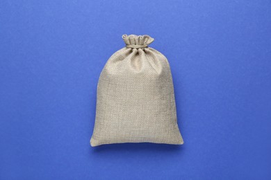 Photo of Tied burlap bag on blue background, top view