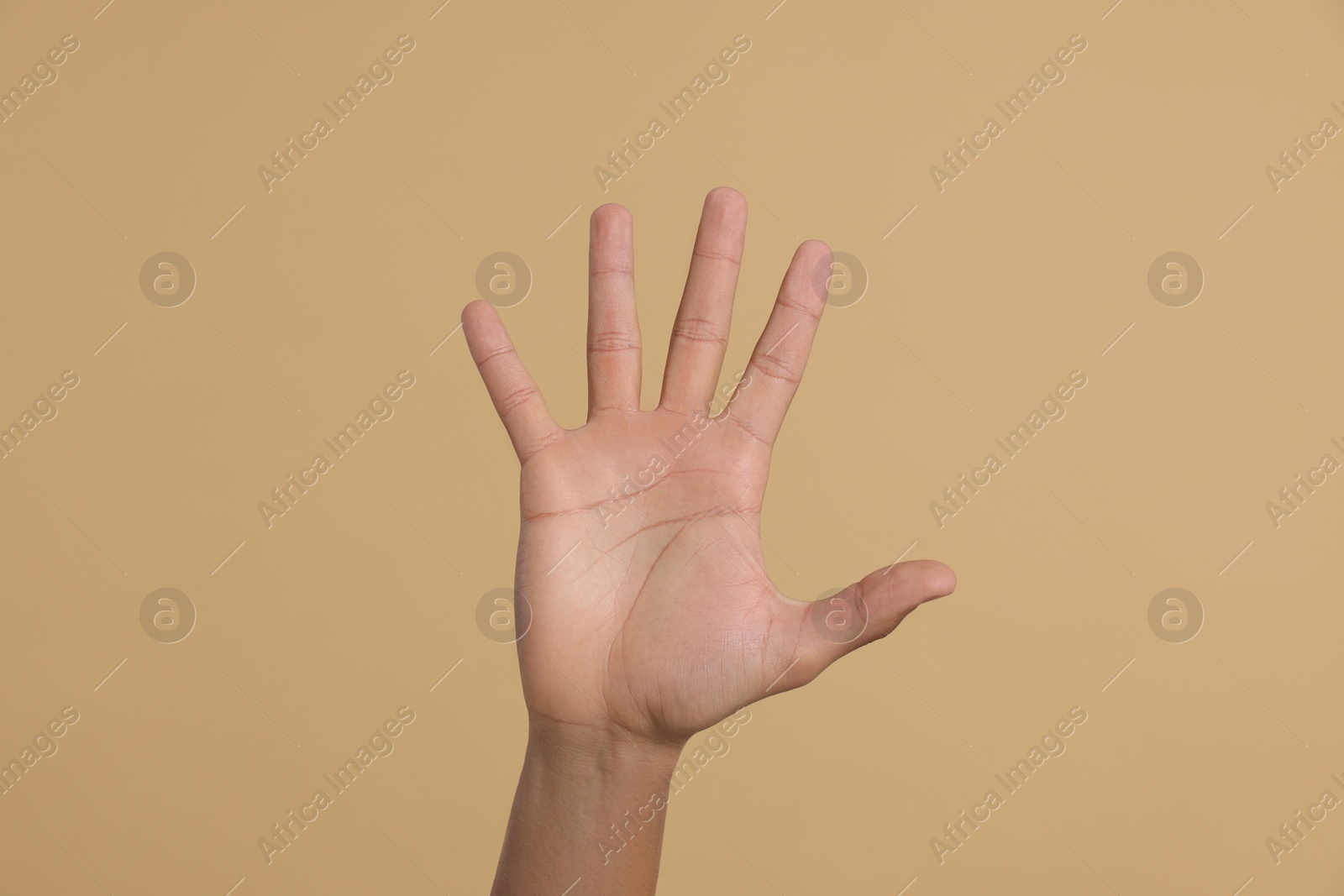 Photo of Man giving high five on beige background, closeup of hand