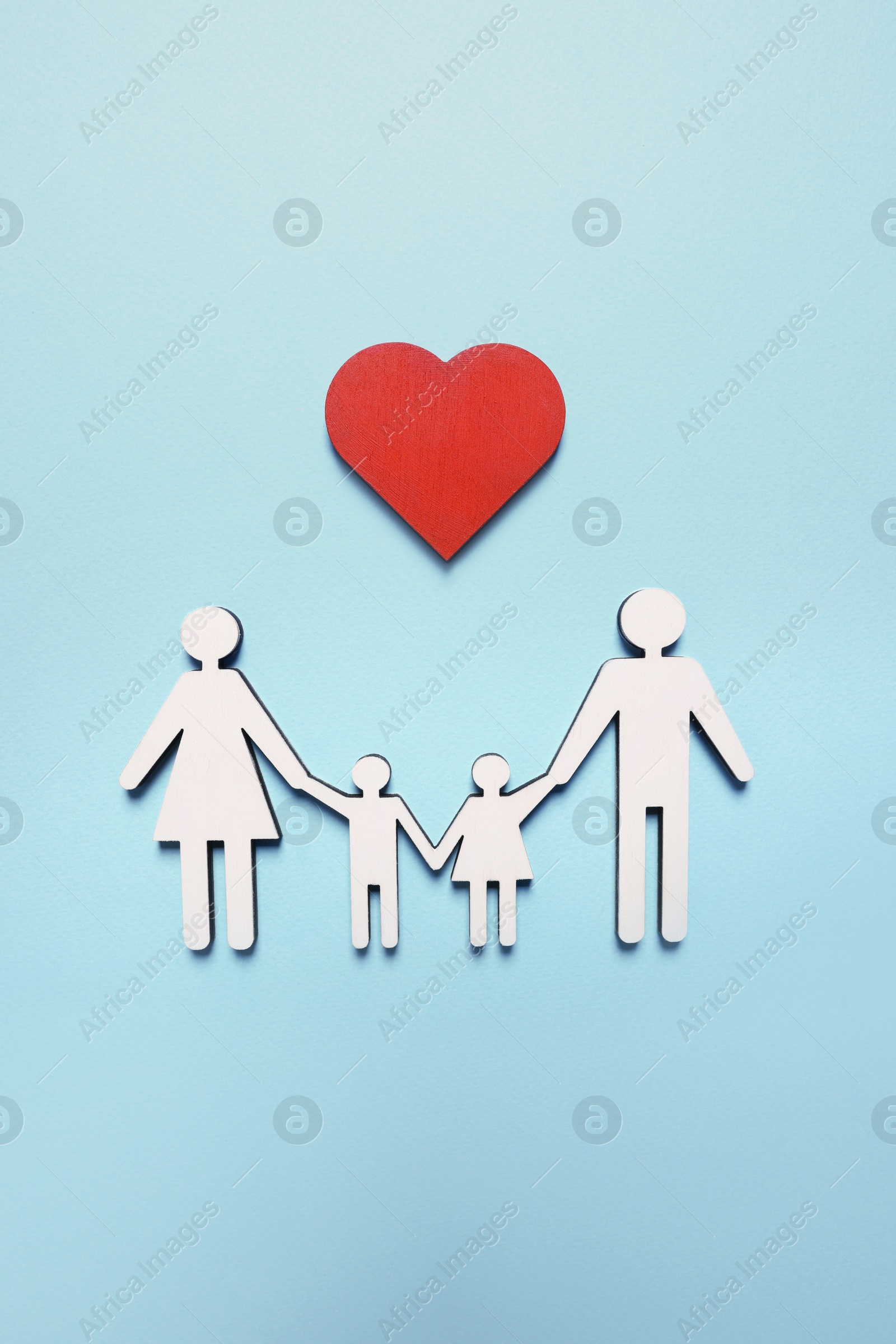 Photo of Figures of family and heart on light blue background, top view. Insurance concept