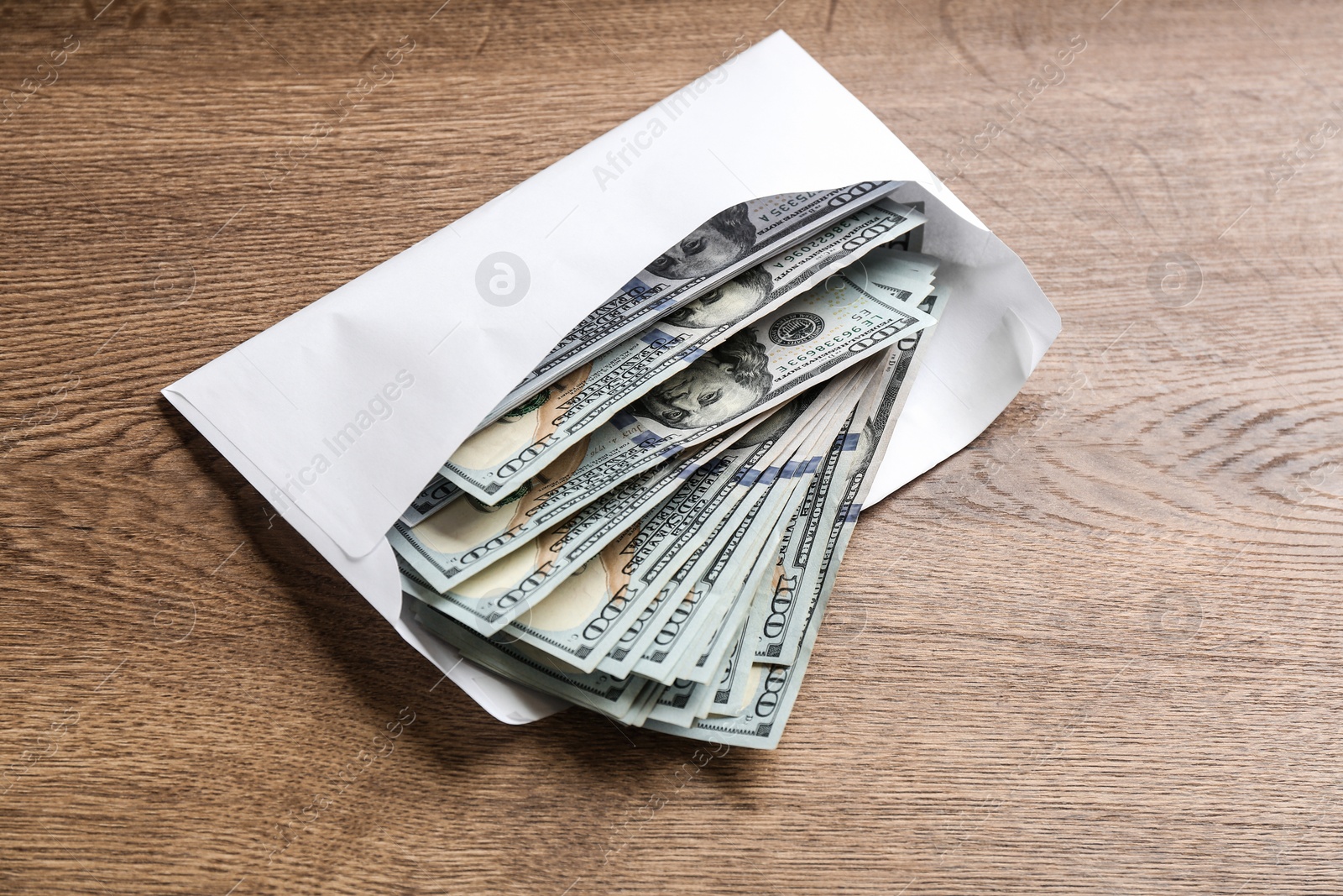 Photo of Envelope with dollar bills on wooden table. Bribe concept