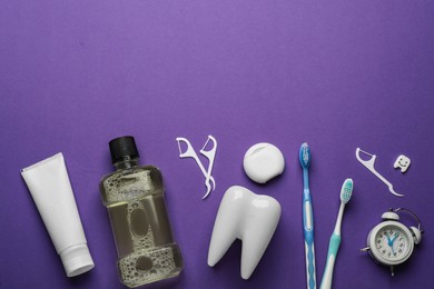 Photo of Flat lay composition with mouthwash and other oral hygiene products on purple background. Space for text