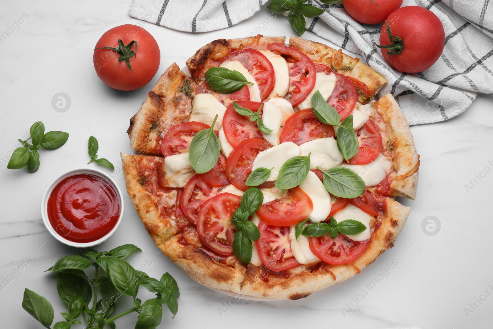 Photo of Delicious Caprese pizza with tomatoes, mozzarella and basil served on white marble table, flat lay