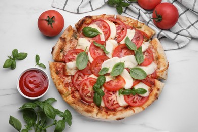 Delicious Caprese pizza with tomatoes, mozzarella and basil served on white marble table, flat lay