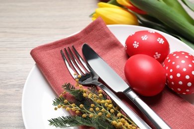 Photo of Festive Easter table setting with eggs on wooden background, closeup
