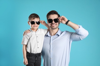 Portrait of dad and his son on color background