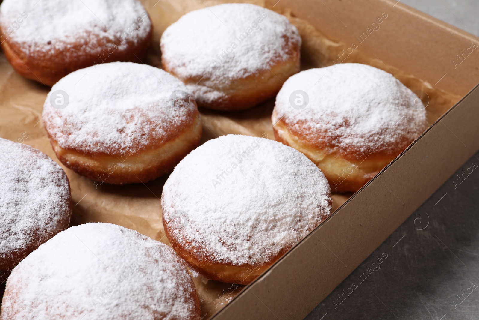 Photo of Delicious buns with powdered sugar on table, closeup