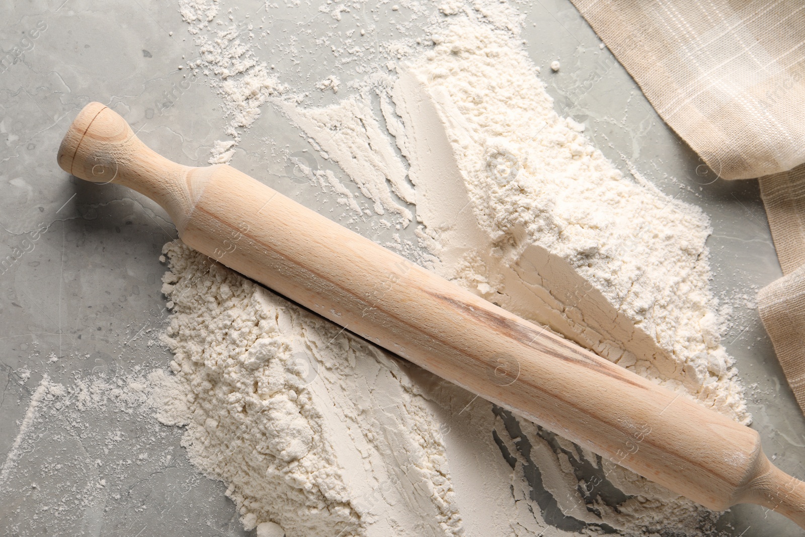 Photo of Pile of flour and rolling pin on grey marble table, top view