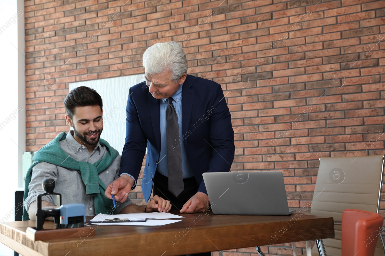 Photo of Senior notary working with client in office