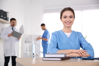 Photo of Portrait of female doctor at table in modern clinic