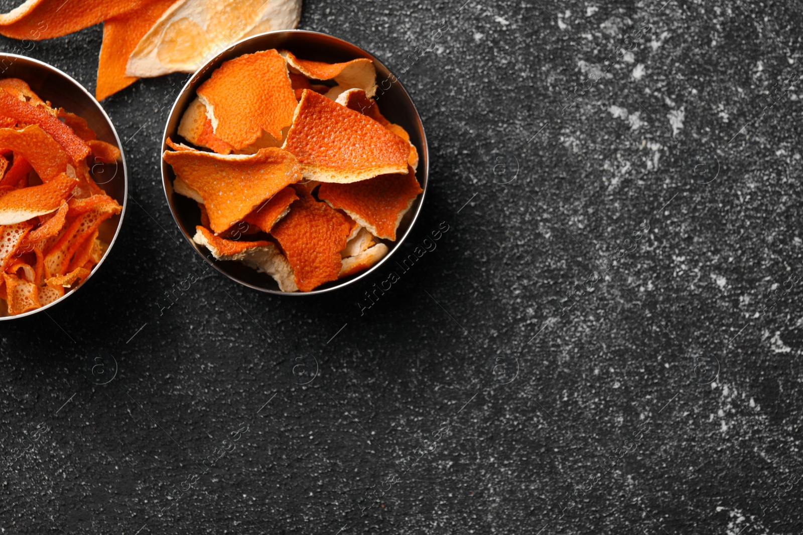 Photo of Dry orange peels on gray textured table, flat lay. Space for text