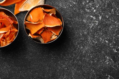 Photo of Dry orange peels on gray textured table, flat lay. Space for text