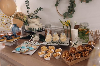 Beautiful cake and other treats on table in room. Baby shower party