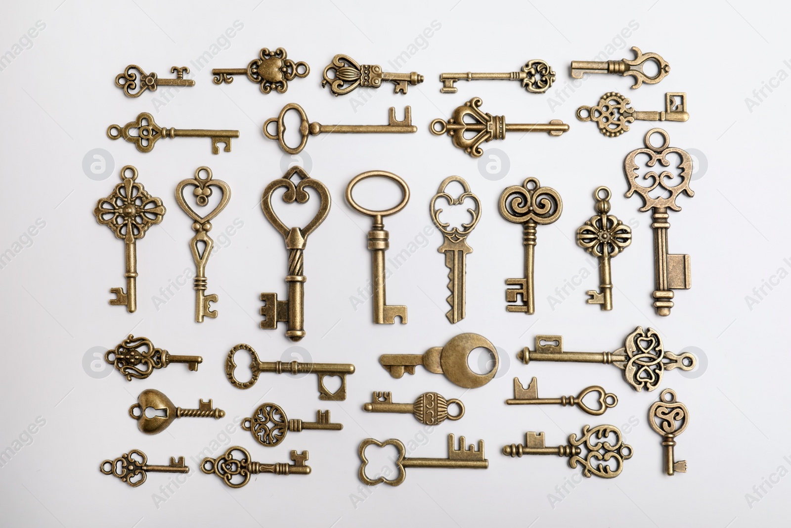 Photo of Bronze vintage ornate keys on white background, top view