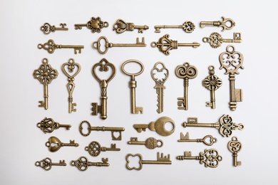 Photo of Bronze vintage ornate keys on white background, top view