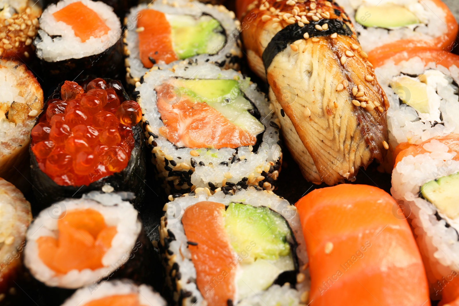 Photo of Different tasty sushi rolls as background, closeup