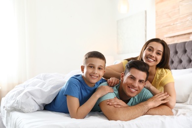 Happy young family together on large bed