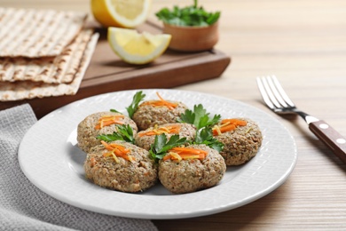 Plate of traditional Passover (Pesach) gefilte fish on wooden background