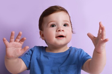 Photo of Cute little baby boy on violet background