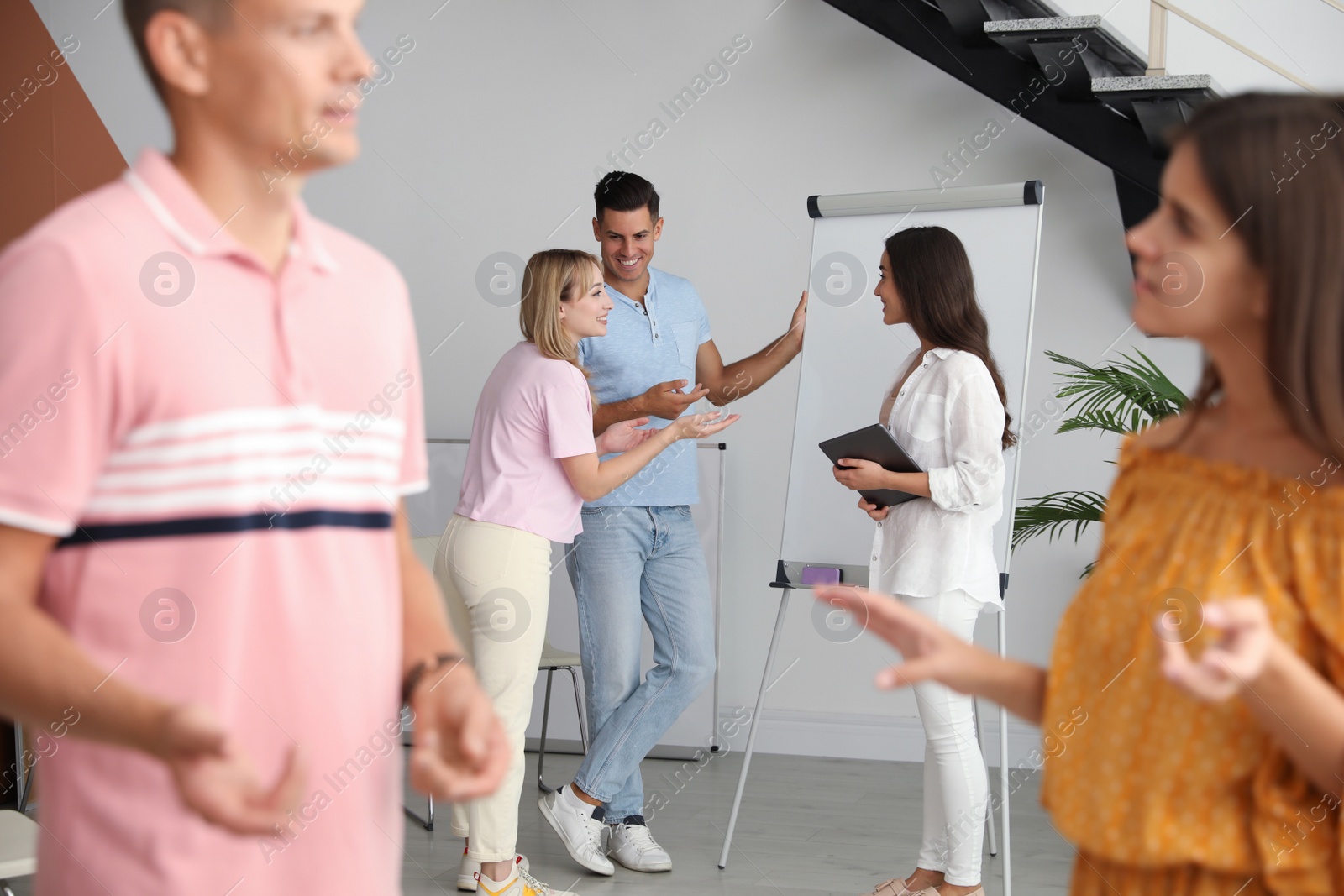 Photo of Group of people talking near whiteboard in hall
