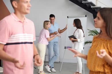 Group of people talking near whiteboard in hall