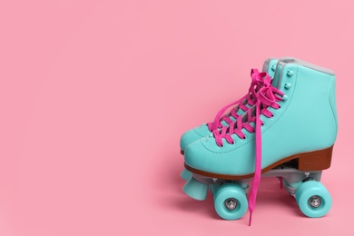 Photo of Pair of stylish quad roller skates on color background. Space for text