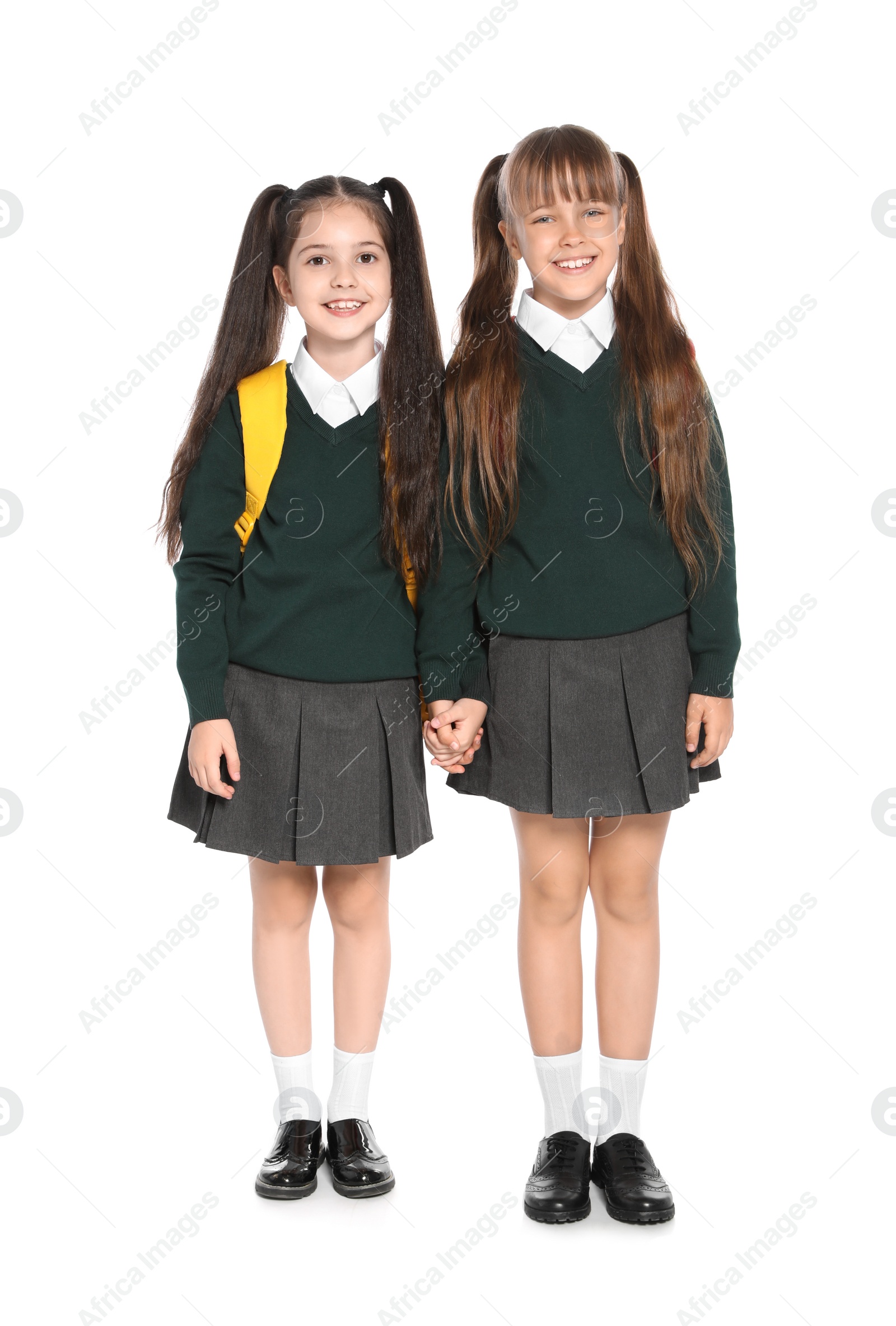 Photo of Little girls in stylish school uniform on white background