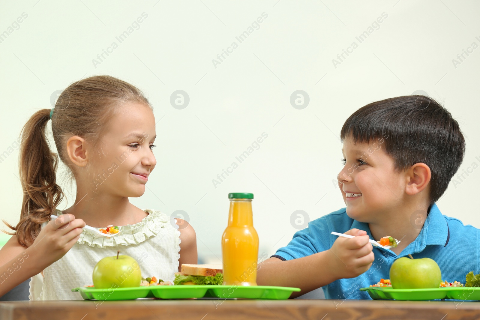 Photo of Happy children eating healthy food for lunch in school canteen