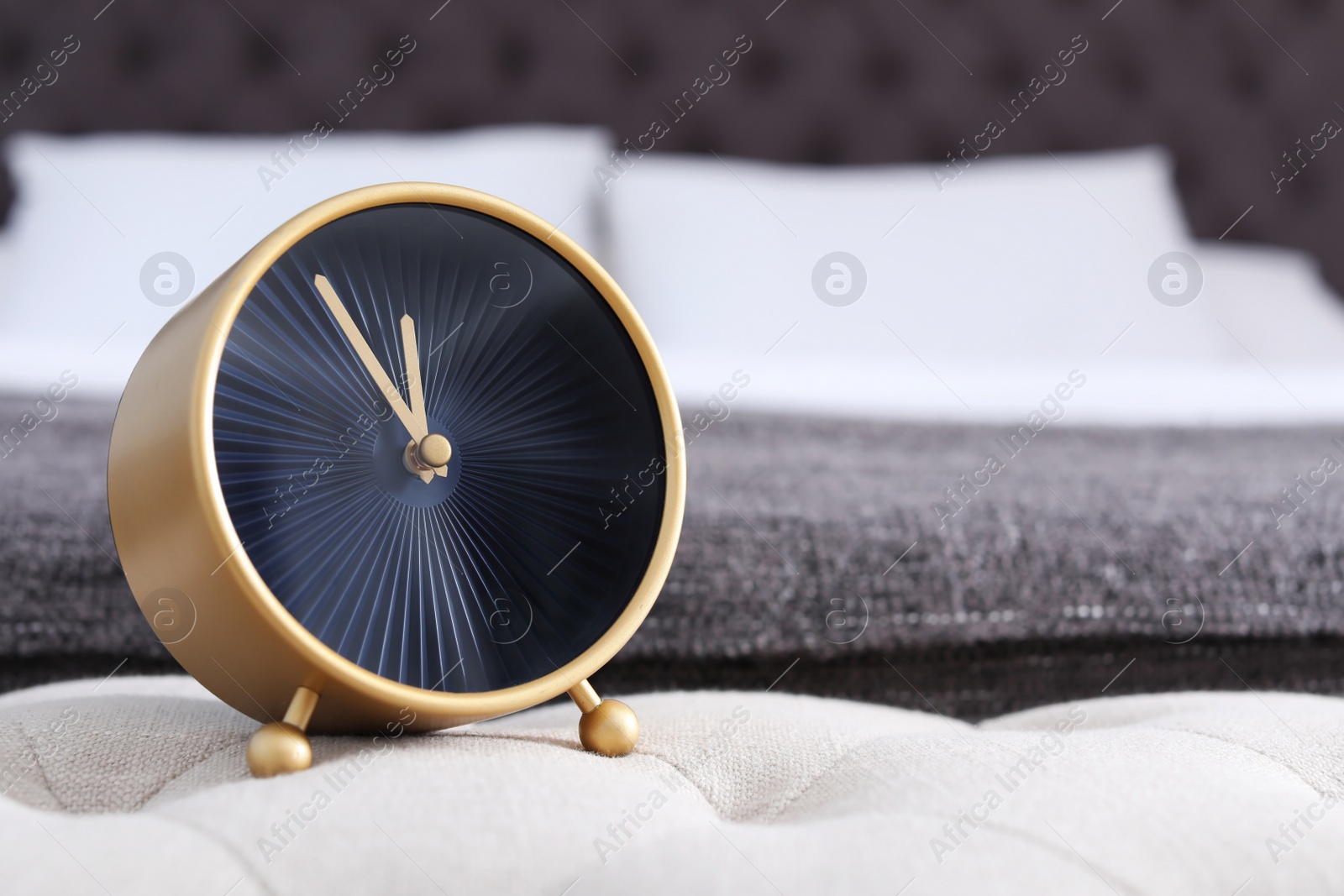 Photo of Stylish alarm clock near bed. Time to wake up