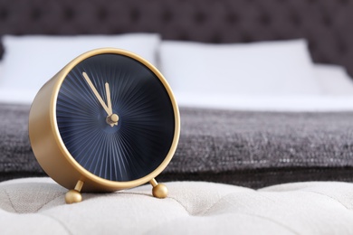 Stylish alarm clock near bed. Time to wake up